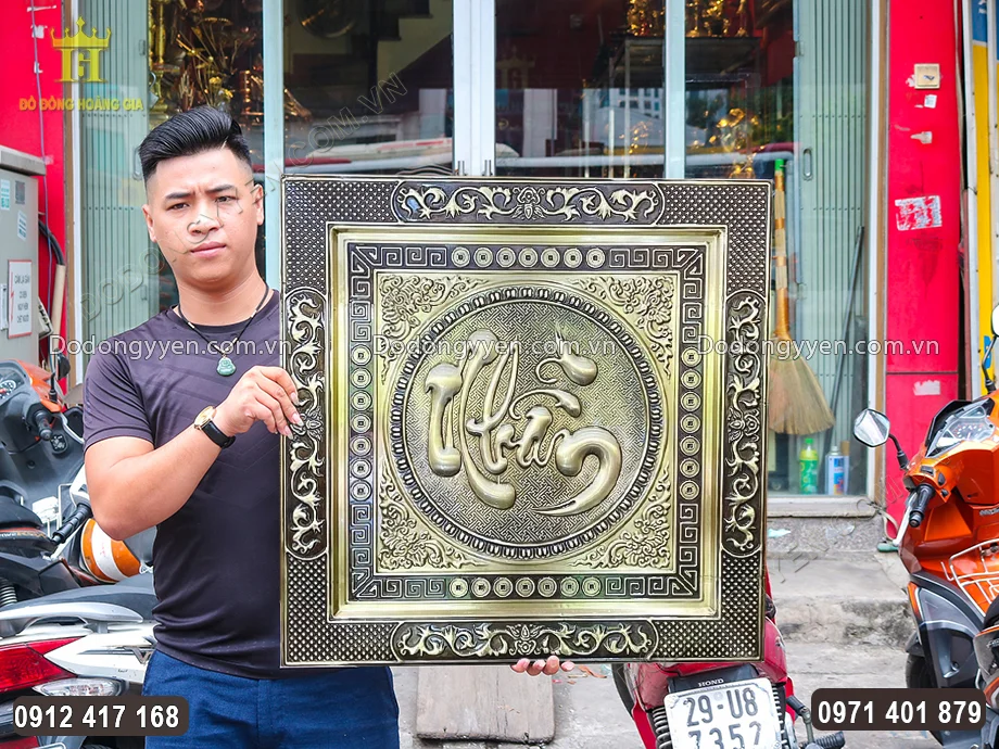 Chữ Nhẫn được chạm th&uacute;c nổi theo lối thư ph&aacute;p ở trung t&acirc;m bức tranh